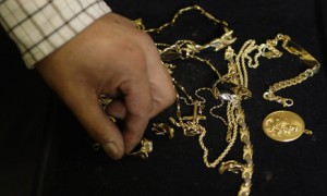 A pawn shop worker sorts through gold jewellery in Madrid