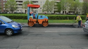 stock-footage-vilnius-lithuania-circa-may-worker-put-hot-asphalt-on-road-street-holes-and-heavy