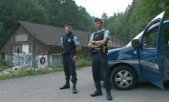 Gendarmes stand by a vehicle on a road near Annecy Lake in Chevaline, southeastern France, in this still image taken from video