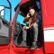 Driver talking by mobile phone while sitting in cabin of big modern truck